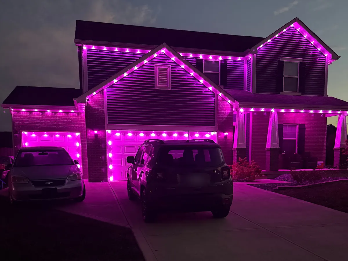 Pink Govee lights along the rooflines, porch and garage doors of a home, installed by J’s Design