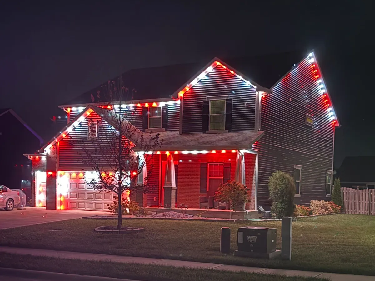 Red and white Govee lights outlining every roofline of a two story home, installed by J’s Design