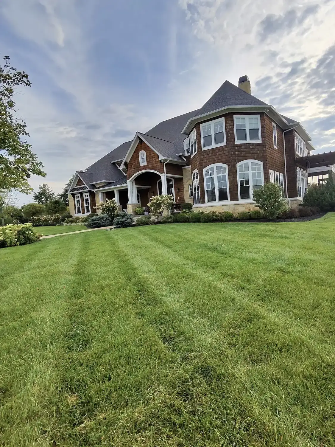 Freshly mowed striped lawn and landscaped front yard by J’s Design Landscaping and Lawncare